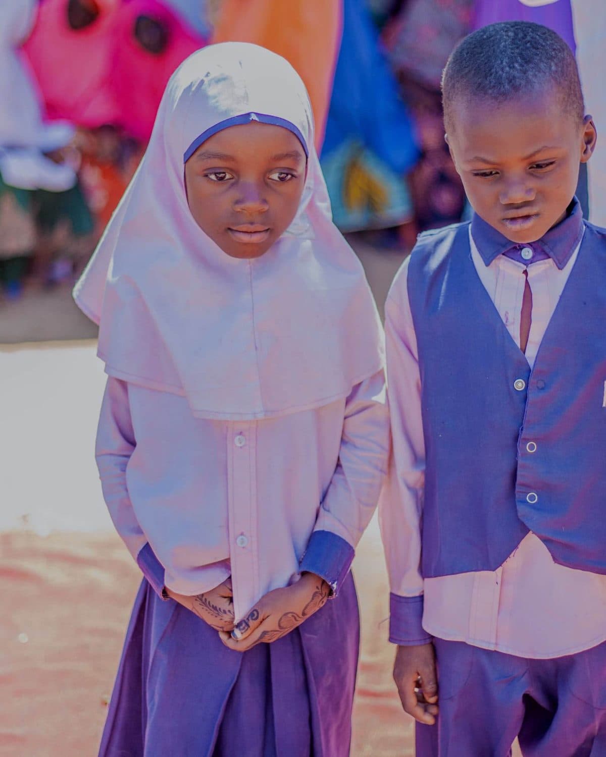 Two pupils in LinkEdu Africa uniform standing side by side at a campus event